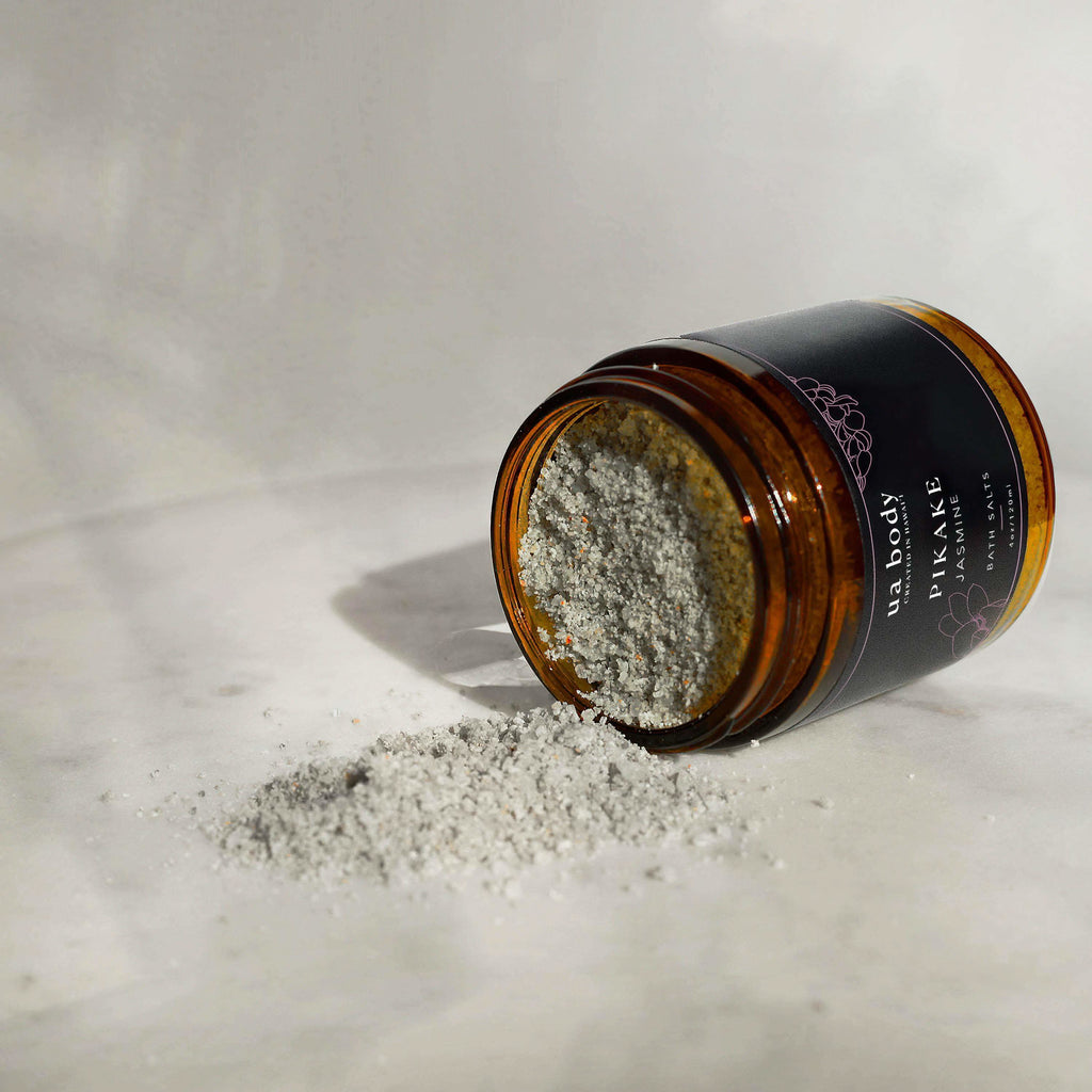 Open jar of Ua Body Pikake Jasmine body scrub on a light surface